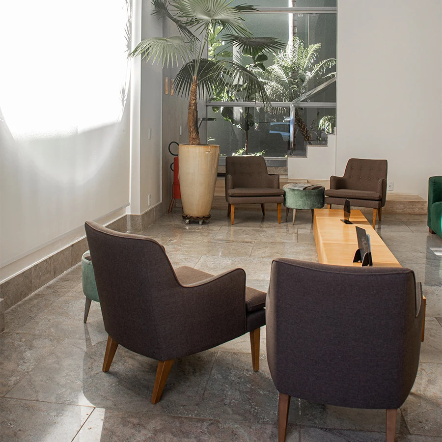 Recepção da Clínica Pelle, com poltronas e jardim junto à janela